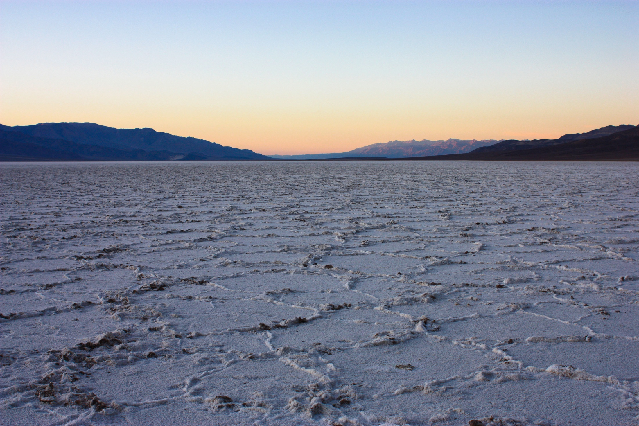 Salt polygons running to the horizon under a dusk gradient, per the photographer's titled set.