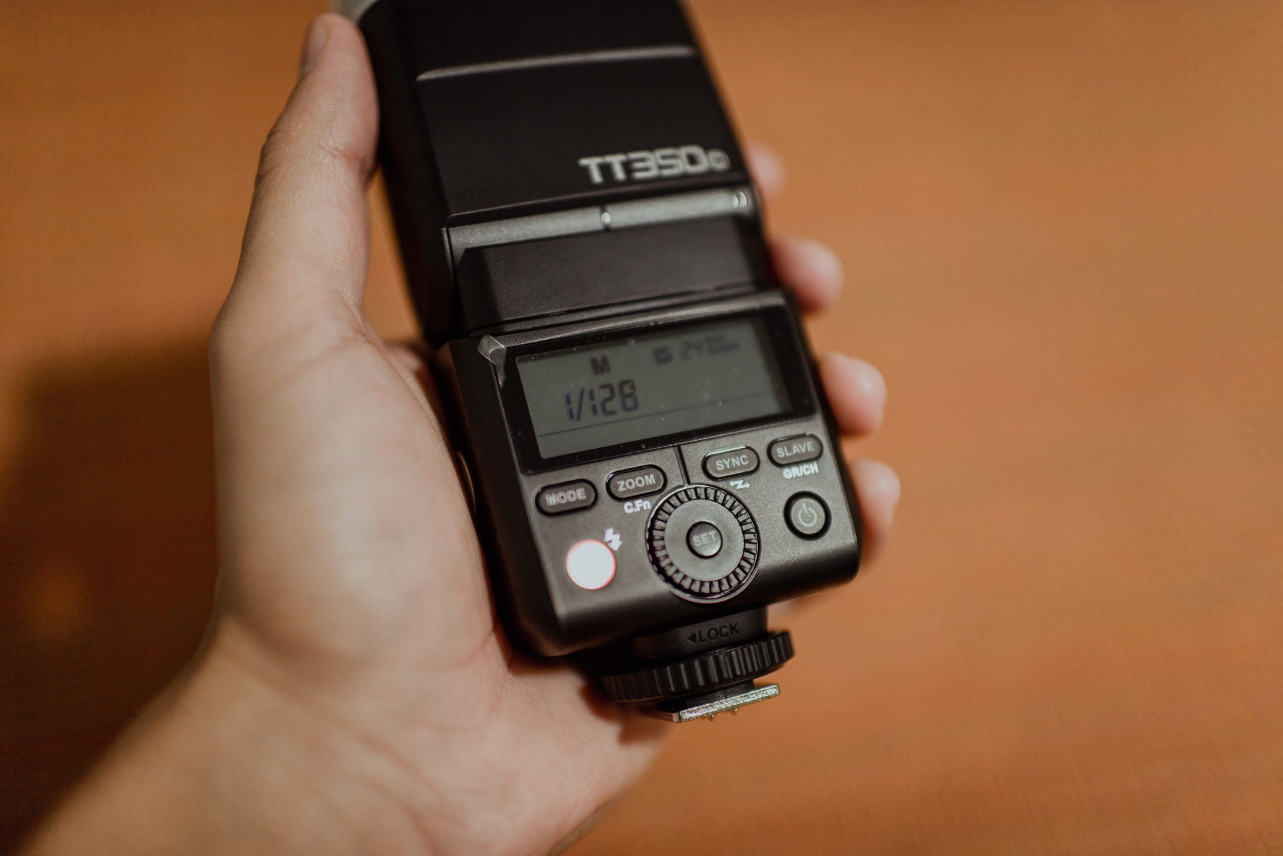 Compact Godox TT350 speedlight held in hand