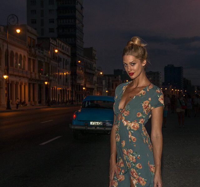 Woman in a floral dress on a city street at dusk