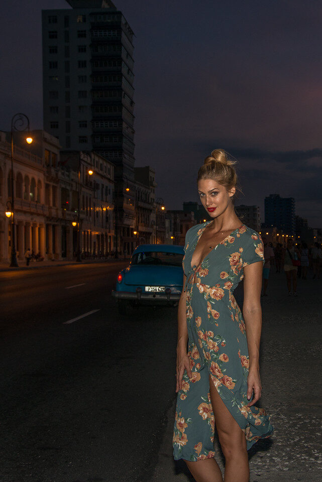 Woman in a floral dress on a city street at dusk
