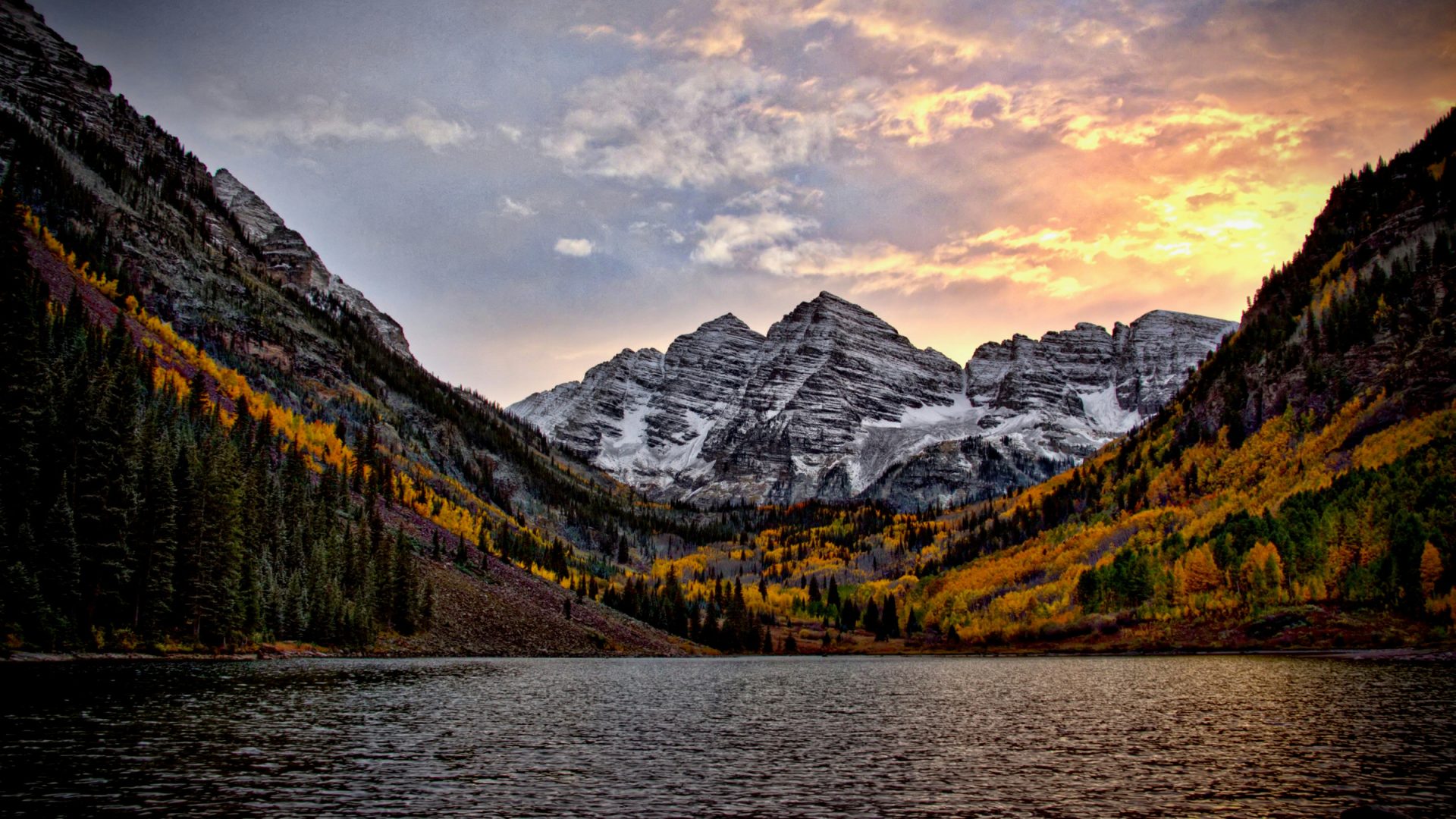 Maroon Bells beneath colorful clouds with rippled Maroon Lake in front