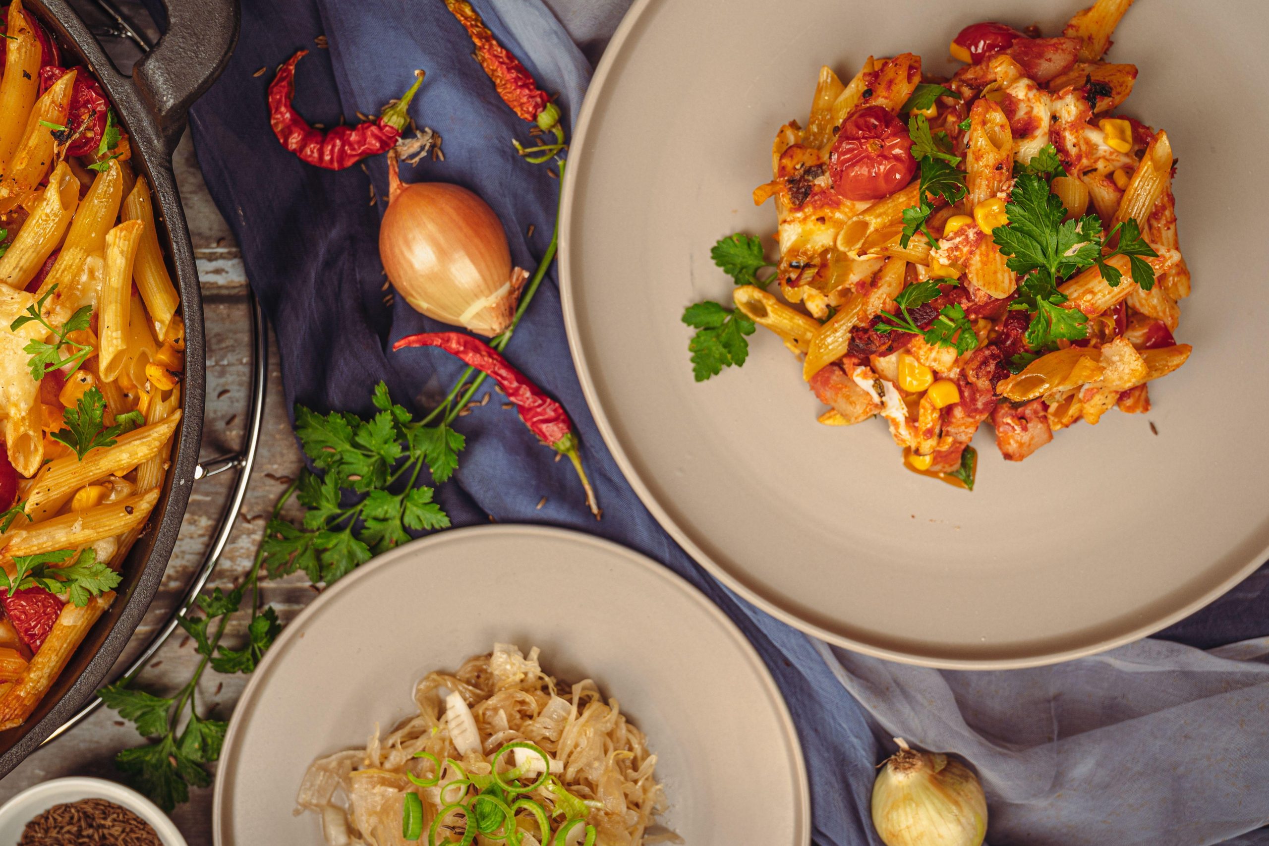 Overhead view of pasta dishes on a dark tabletop. (Stock photo, illustrative.)