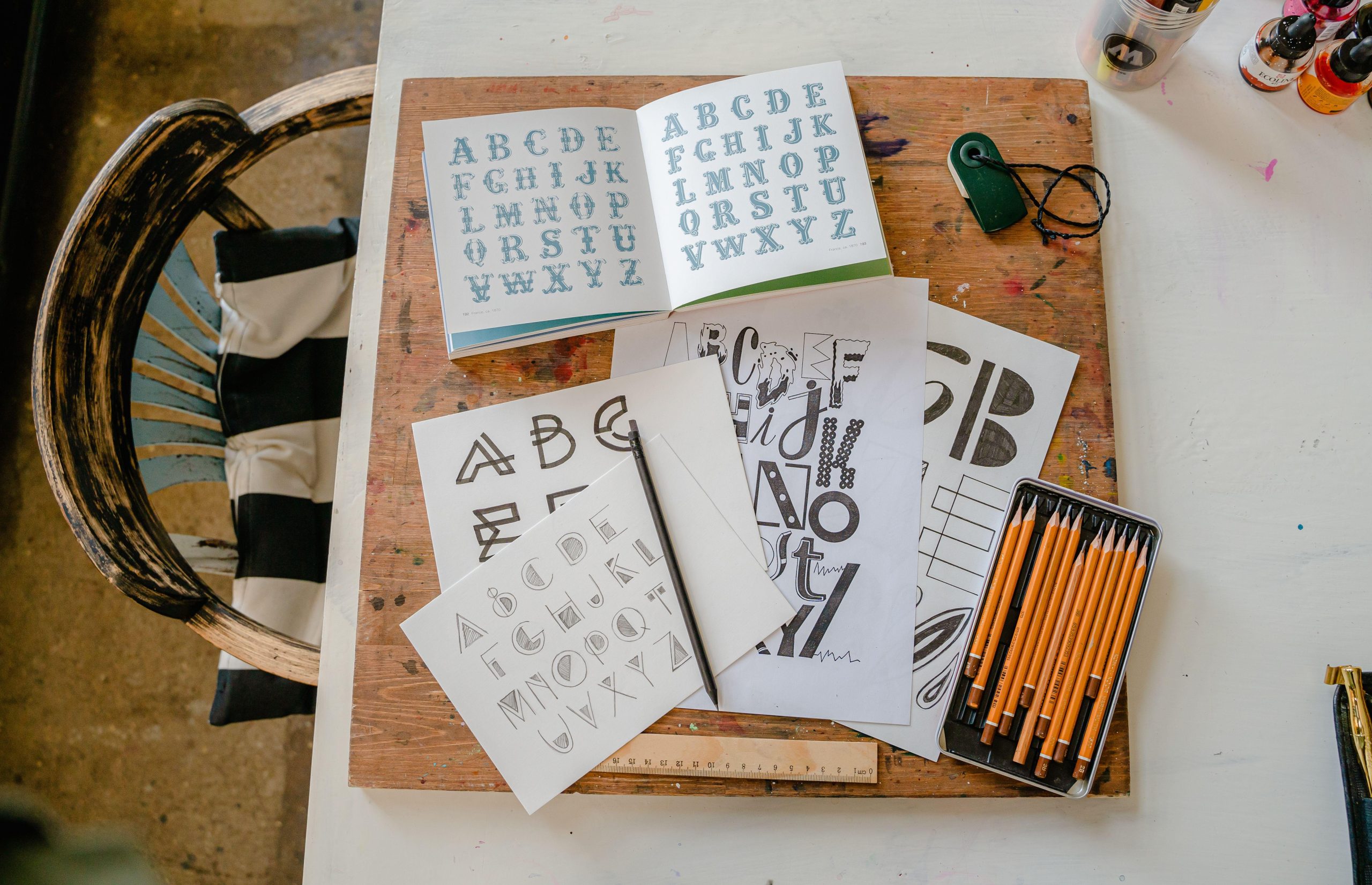 Lettering samples and pencils on a design table. (Stock photo, illustrative.)