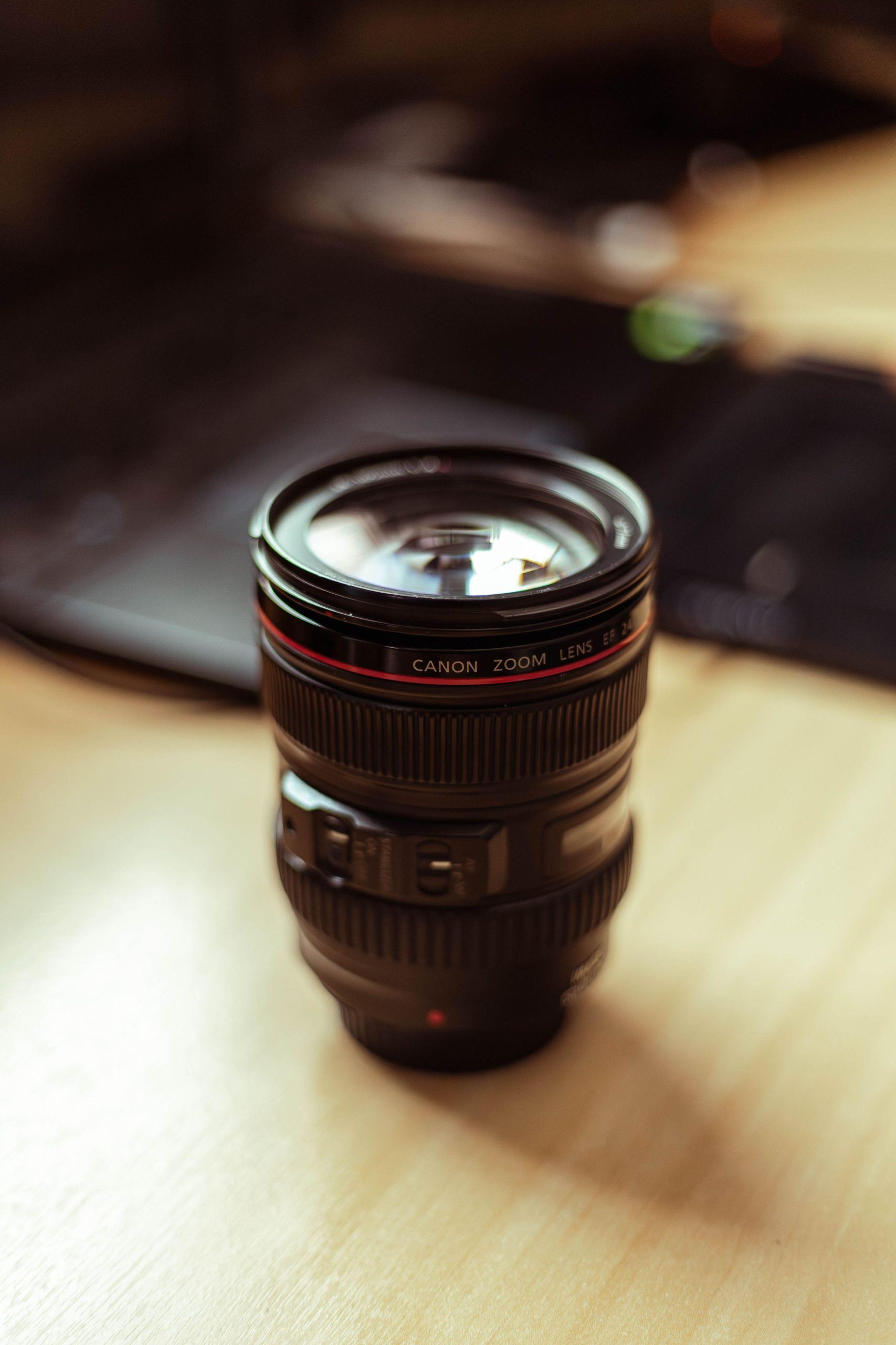 Canon zoom lens on a wooden desk. (Stock photo, illustrative.)