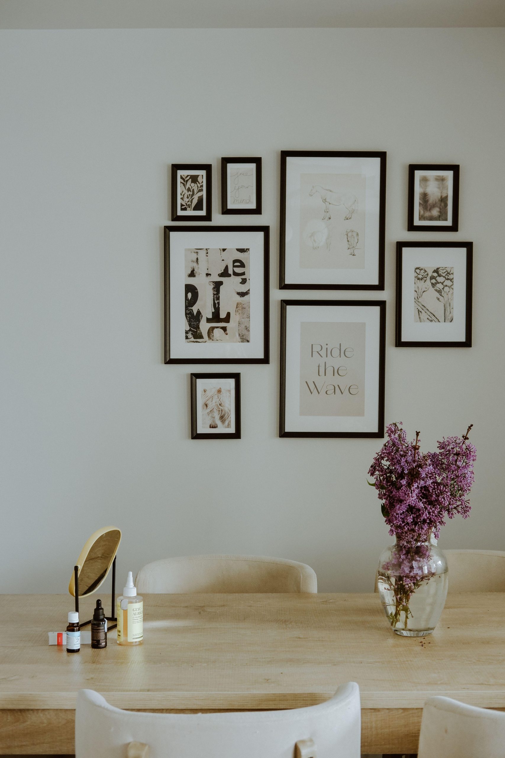 Framed wall art above a dining table with pink flowers. (Stock photo, illustrative.)