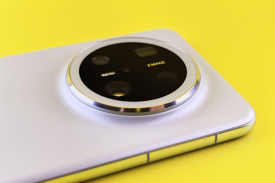 Close-up of a smartphone camera module on a bright yellow background. (Stock photo, illustrative.)