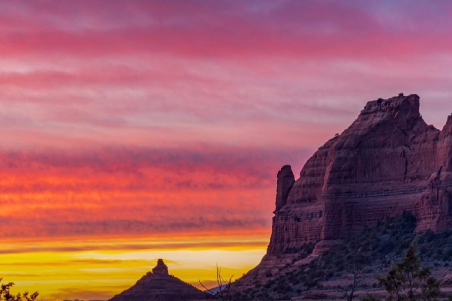 Sedona red rock formations beneath a pink and gold sunset sky