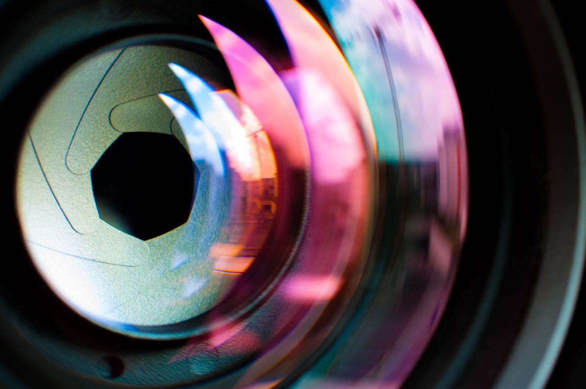 A conceptual image showing a close-up of a camera lens with a blurred background, representing depth of field in photography.