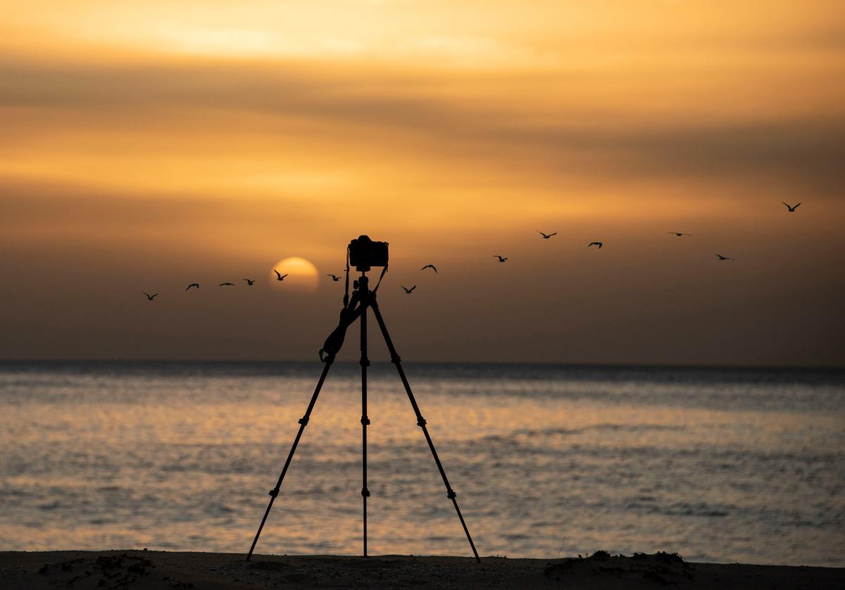 A professional photographer setting up a tripod at an event to capture high-quality images