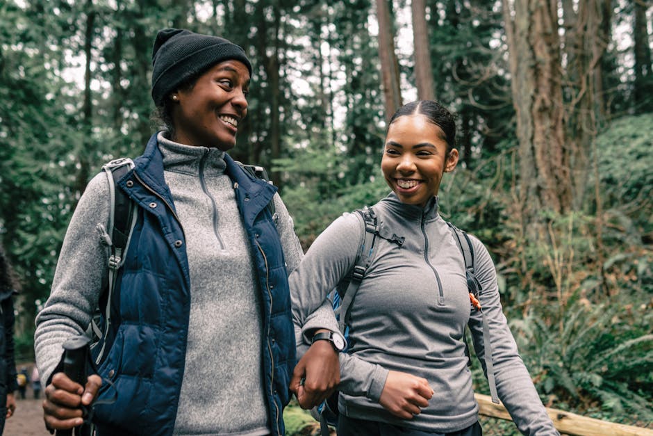 A group of women on an adventure travel trip, hiking through a beautiful natural setting. The women appear happy, bonded, and supportive of each other, showcasing the camaraderie and empowerment of women-only travel experiences.