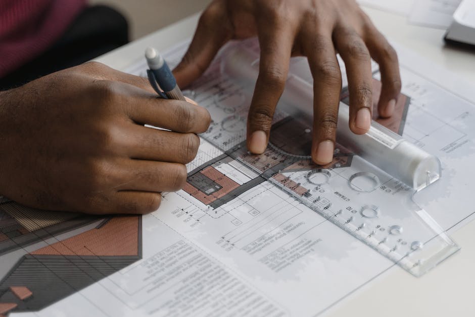 A photo of an iPhone on a table next to architectural blueprints, showcasing the connection between photography and architecture.