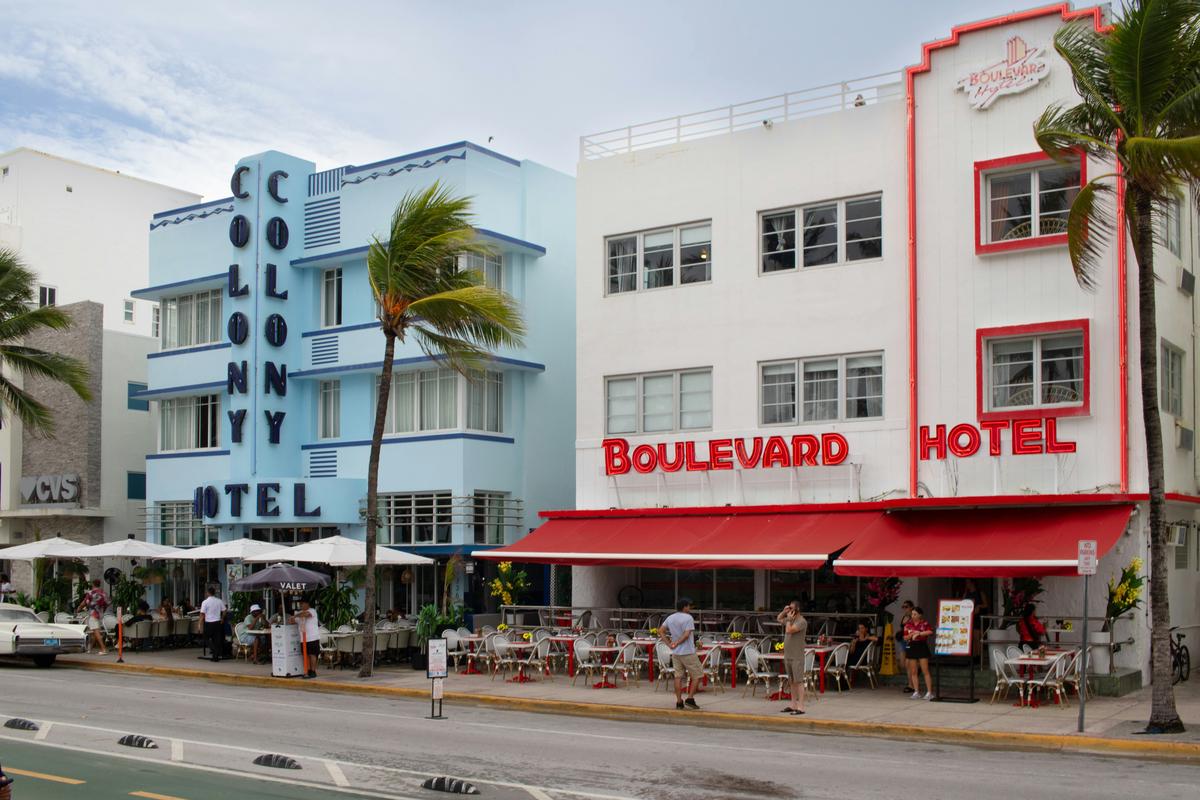 Colorful Art Deco buildings along Ocean Drive in South Beach, Miami, with palm trees and vintage cars